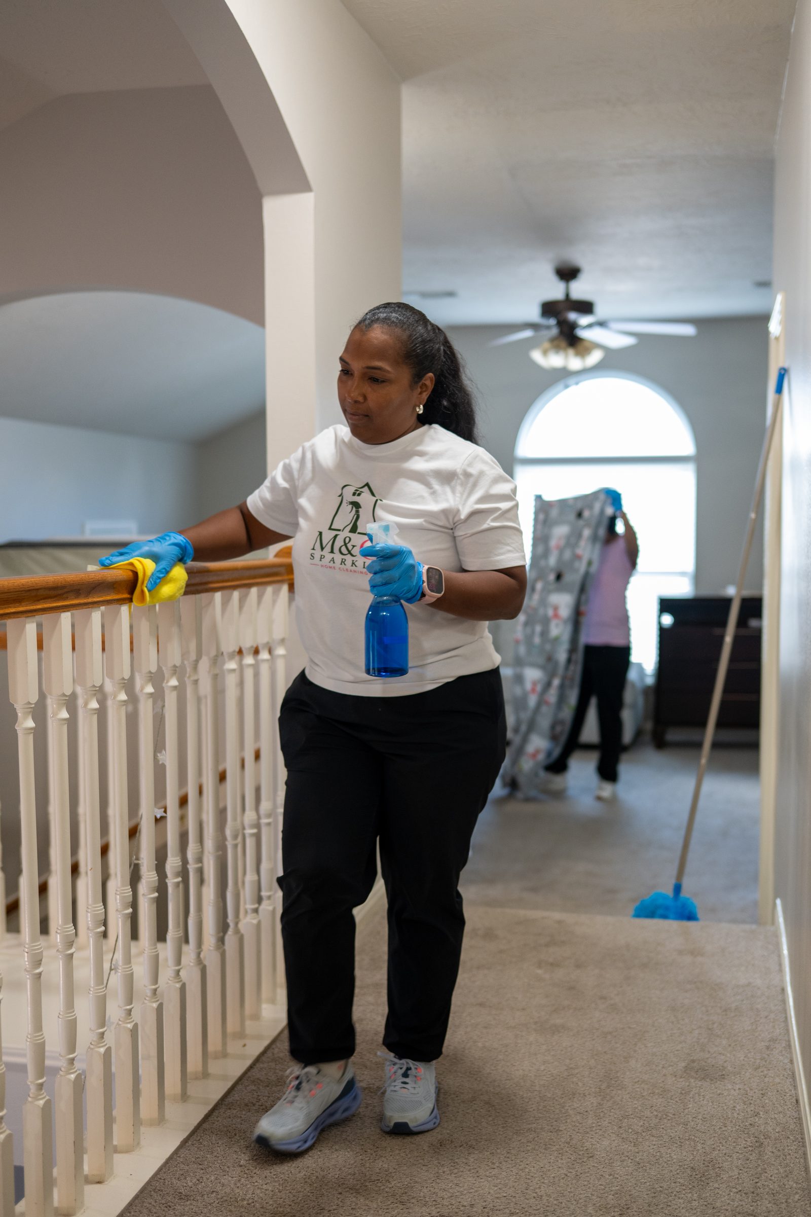 Wiping a stair rail on a two-story Houston home